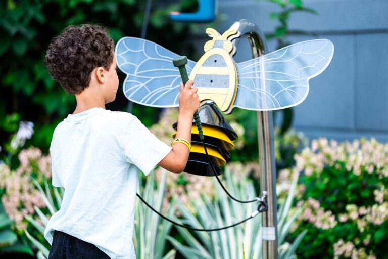 Un niño juega con el abejorro interactivo en el jardín de los polinizadores.